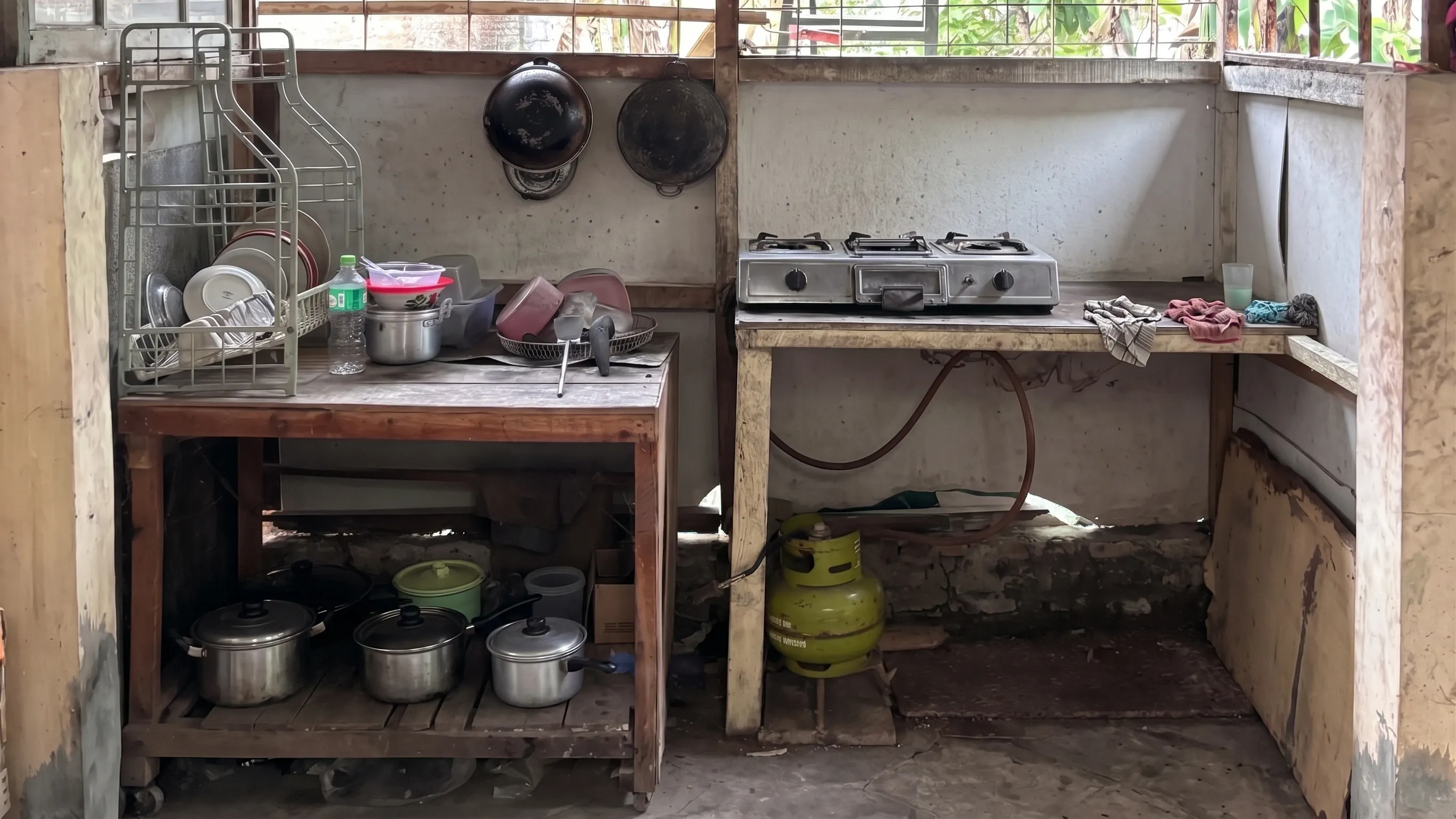 Dapur bersama dengan kompor gas, rak piring, dan peralatan masak