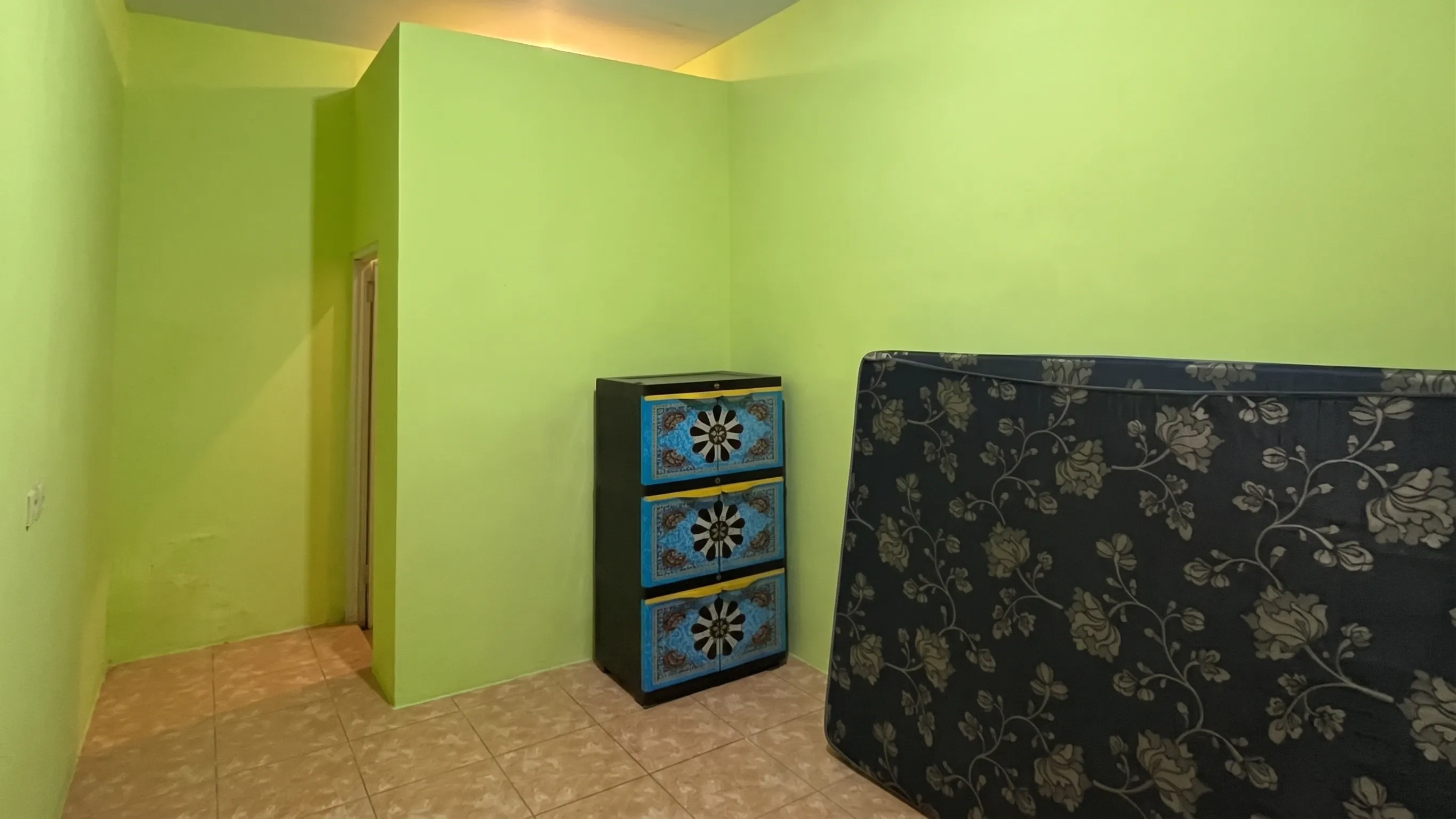Kamar berdinding hijau dengan lemari dan kasur